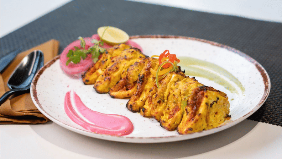 A plate of golden-brown appetisers with a sauce and garnish, stating Happiness served on a plate! at Cenneys Gateway.