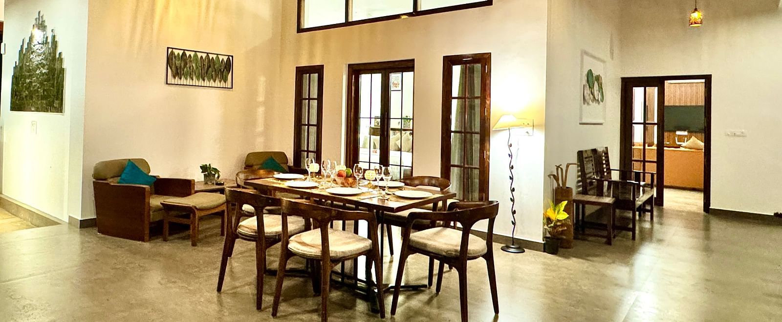 Spacious villa dining and living area with warm lighting - BluSalzz Collection - Tranquil Resort, Wayanad