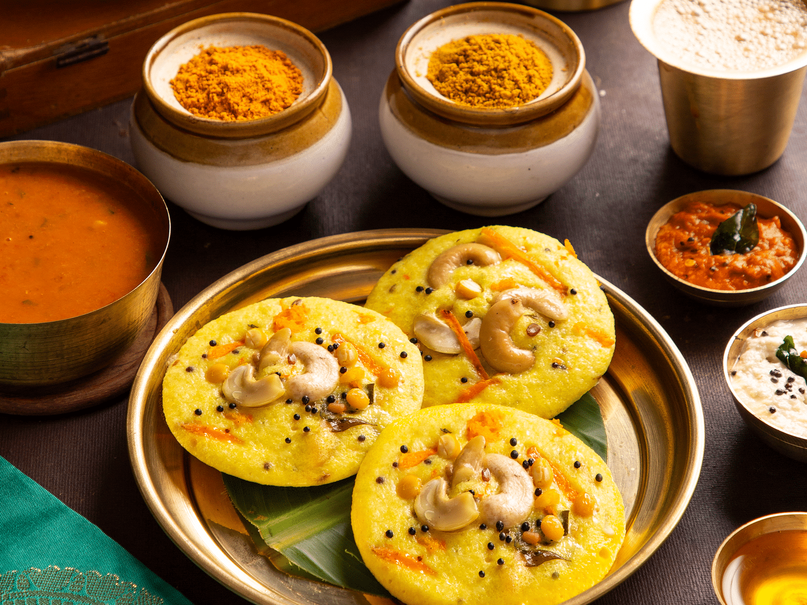 Delicious Indian meal served on a banana leaf, featuring rice and various curries. | Kamats India