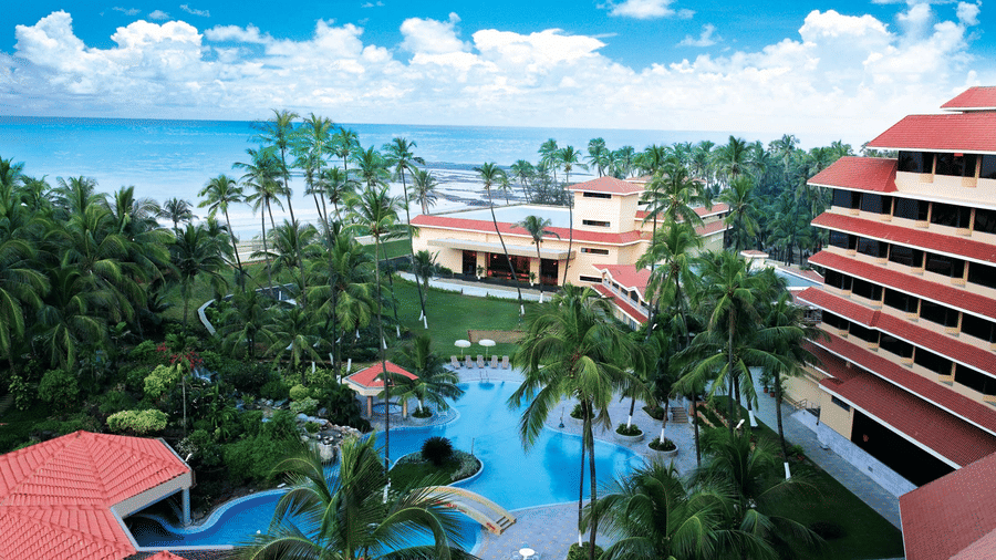A facade image of The Retreat Hotel and Convention Centre featuring a swimming pool in the hotel premises with greenery around