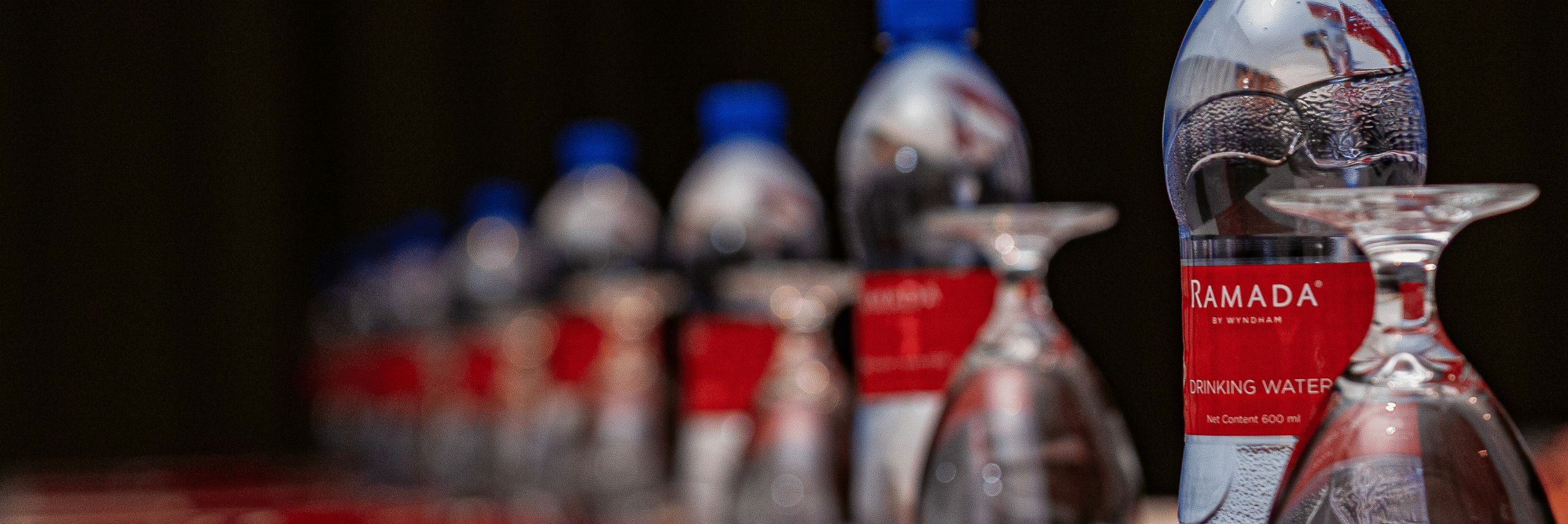 A close up shot of a table with a water bottle, pen and a book placed on a table - Ramada by Wyndham Addis, Addis Ababa.