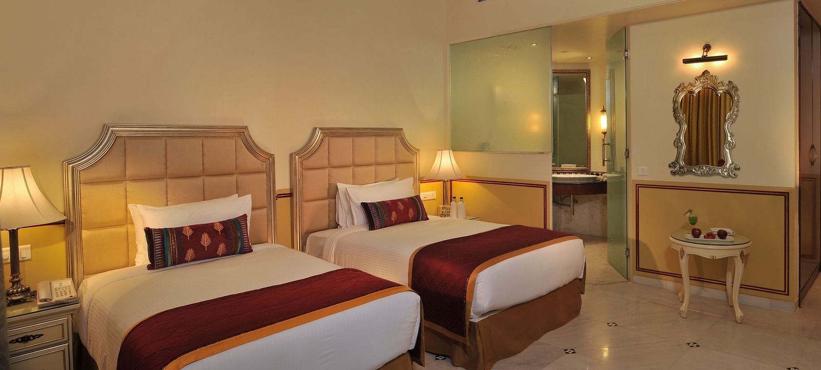 Image of a room with two beds and lamps on the sides of the bed at Rajasthali Resort & Spa Jaipur.