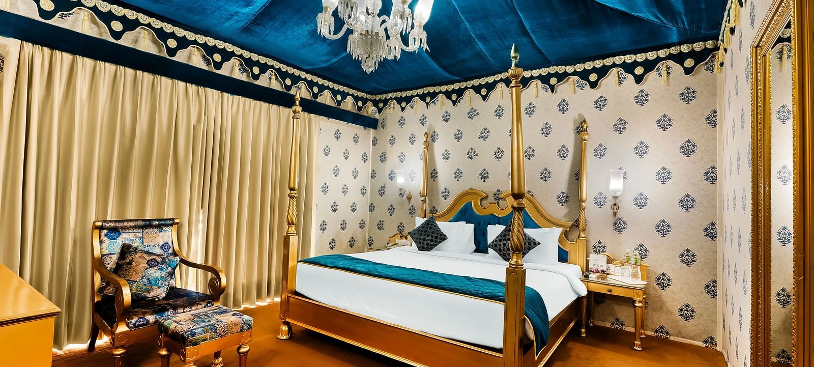 An overview of a tent with a double bed, a chair and a small table - Rajasthali Resort & Spa, Jaipur.