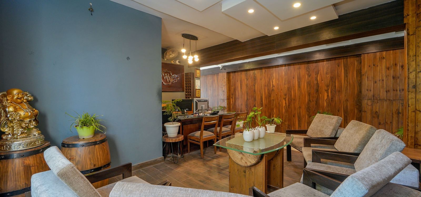 The reception and lobby area of DLS Whispering Winds with sofa set, table, chairs, and a reception desk