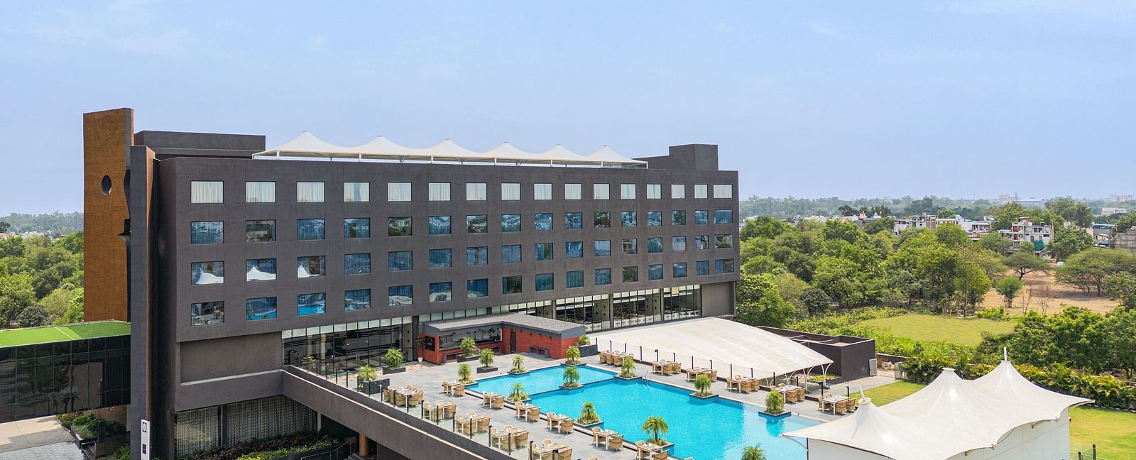 Exterior with the swimming pool in view of Essentia Luxury Hotel, Indore during the day.