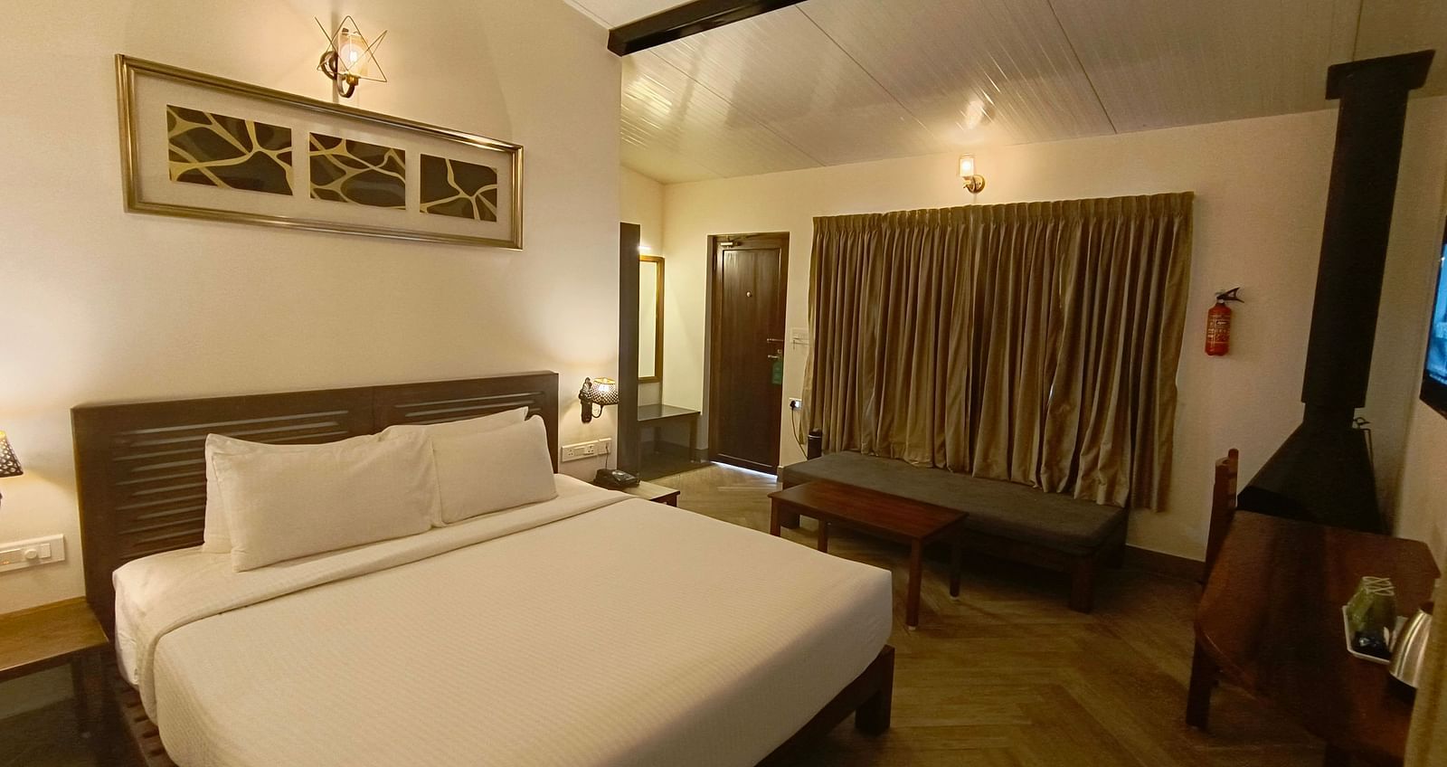 Classic room with a queen-size bed, cozy seating area, and warm lighting.