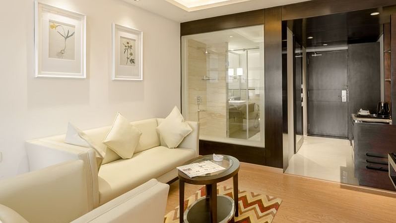 A Hotel suite living area with sofa, table and chic lighting - TGI Grand Fortuna, Hosur