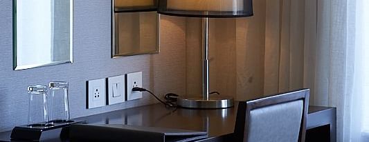 A workstation with a table lamp, and sockets at The Hamuse Hotel, Kodaikanal