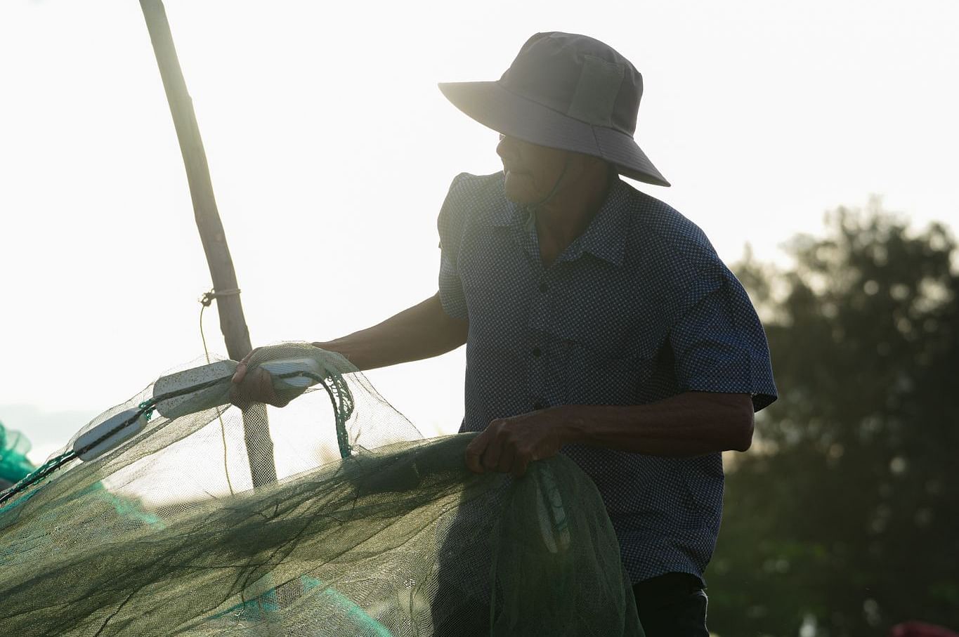 A fisherman reeling in his catch on the beach