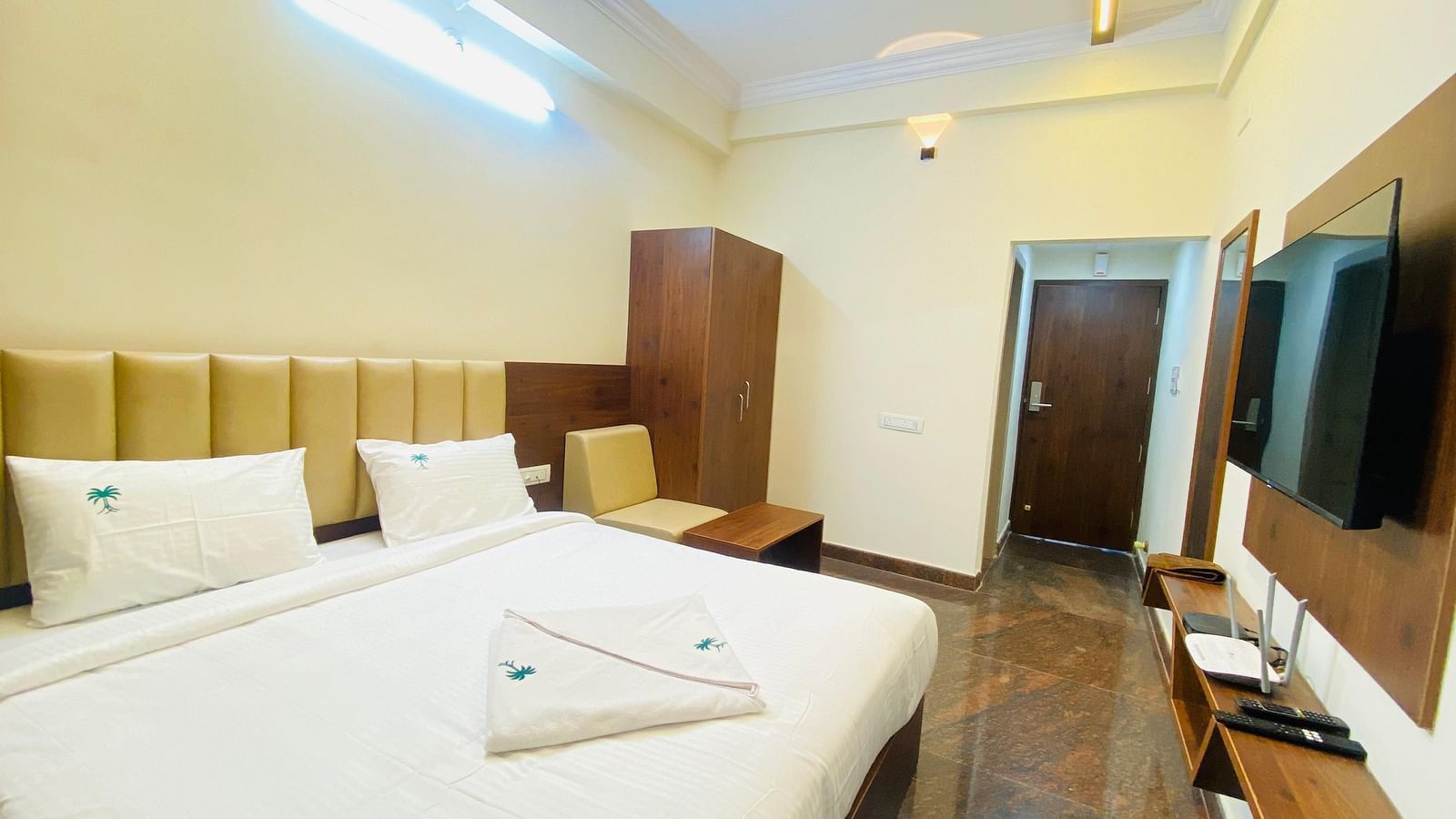 Well-lit deluxe room with plush bedding and stylish wood accents for a restful stay at Hotel Sahara Tree.