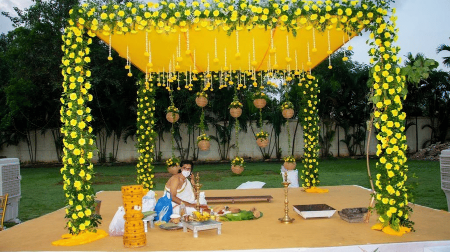 Close-up of a ceremonial mandap decorated with vibrant yellow flowers and hanging elements at Ilara Hotels & Spa, OMR, Chennai