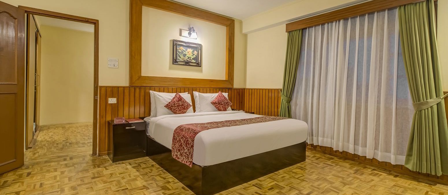 Image of a room with bed and large windows at Summit Tashi Ghang Heritage Resort, Pelling