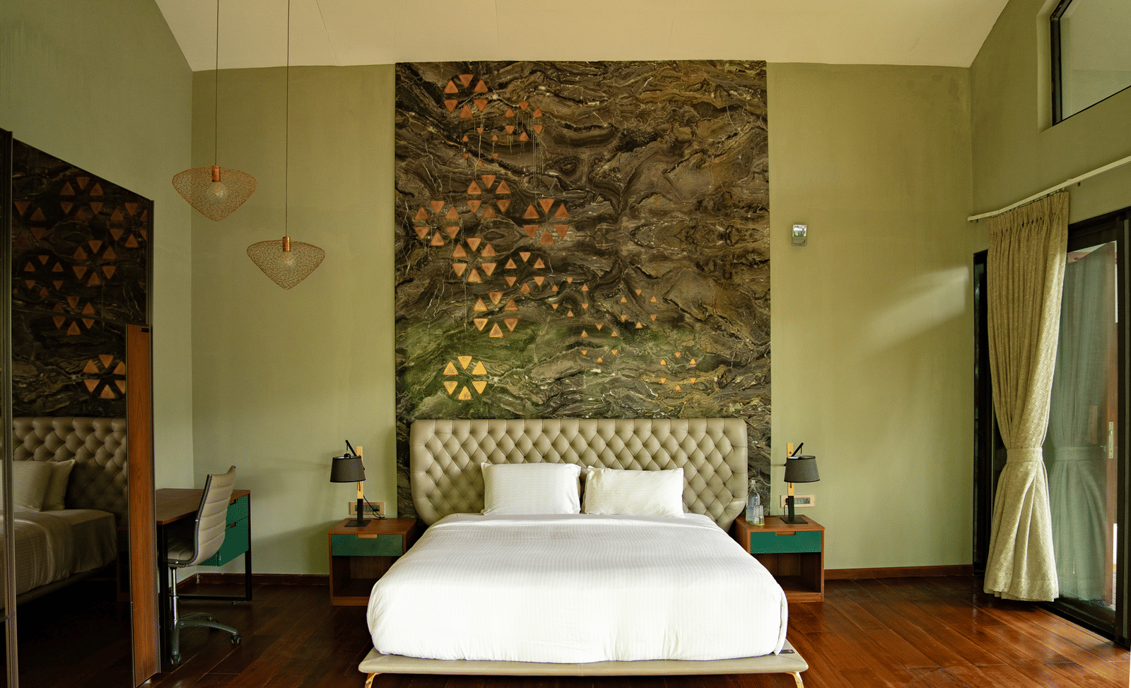 A bedroom at Stanley Revelation with a double bed, a tall tufted headboard, and decorative wall art.