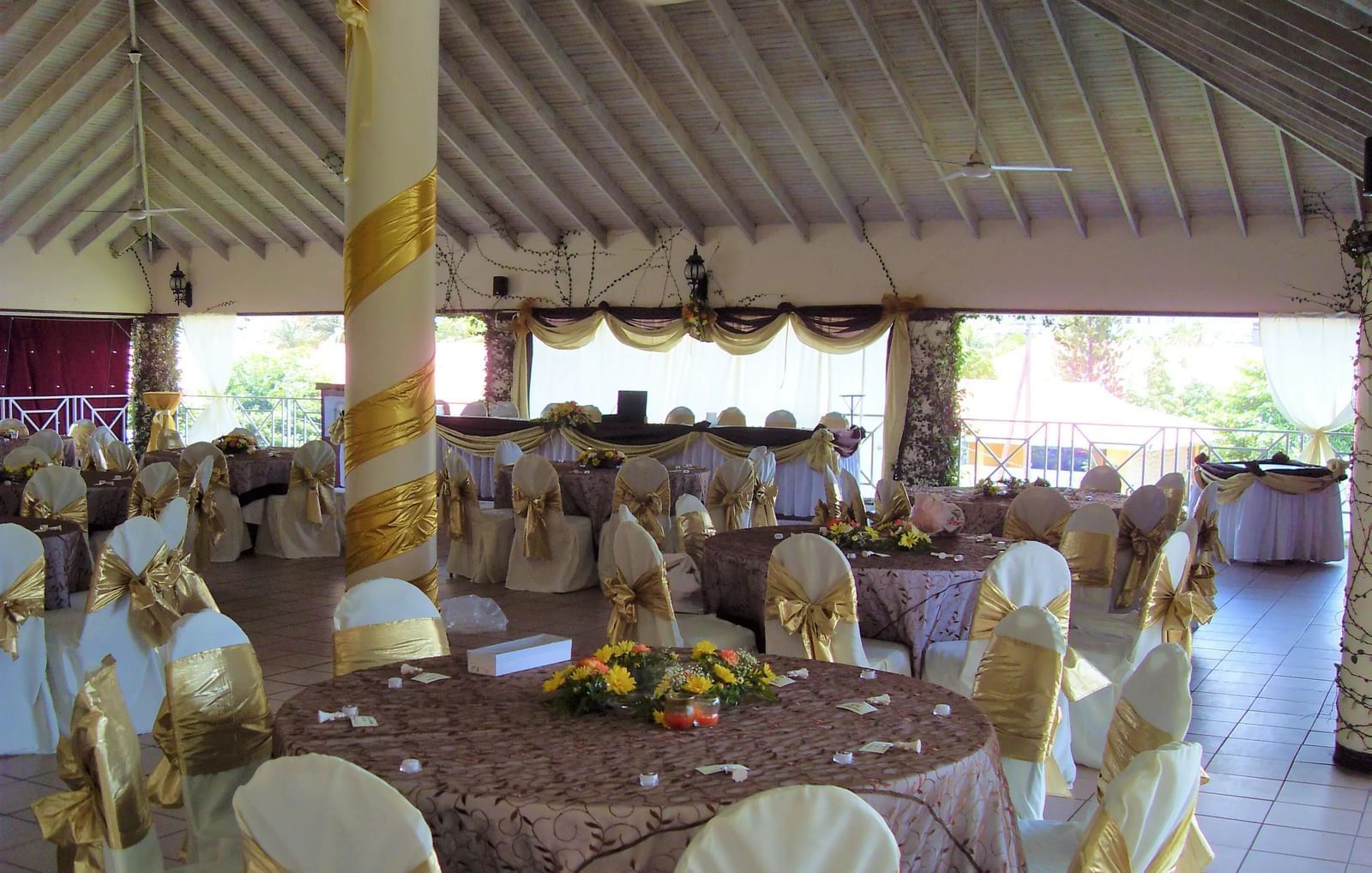 An event space with tables and chairs set up under a covered structure, possibly for a reception or meal | Roof Terrace | Altamont Court, Jamaica