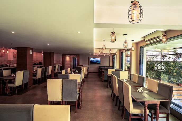 Image of M Cafe with sofa and tables at Vagator Downtown, Goa
