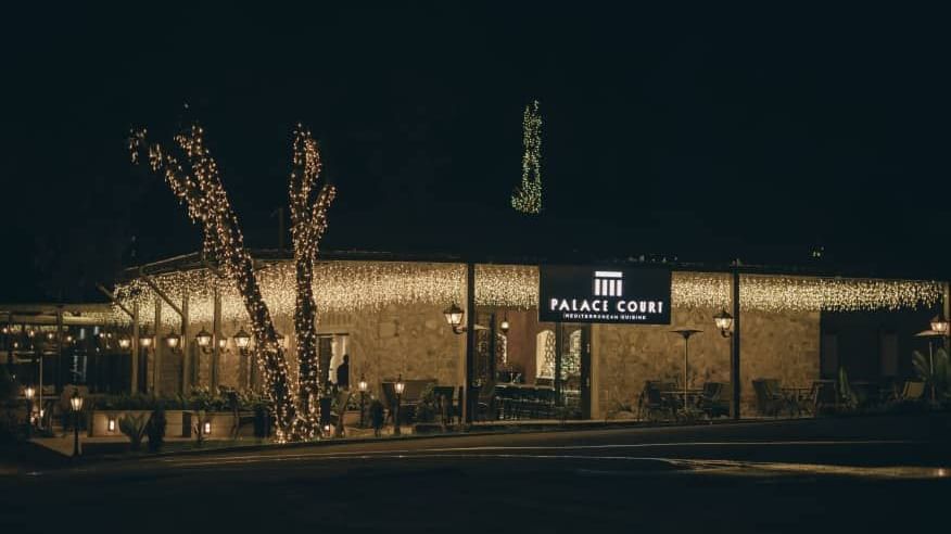 Restaurant exterior at night, showing the brightly lit building entrance at Ramada by Wyndham Addis, Addis Ababa.