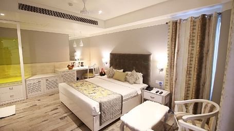 A stylish hotel room with a comfortable bed, elegant furnishings, and soft lighting - Hotel Emerald, Chandigarh