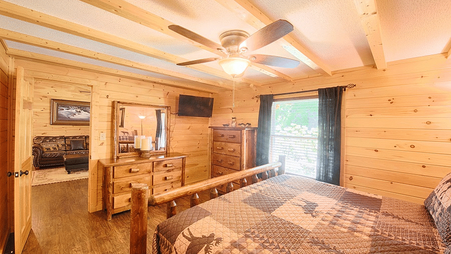 corner view image of a bedroom with a double bed with ample natural light coming from the window beside it - Historic Tapoco Lodge