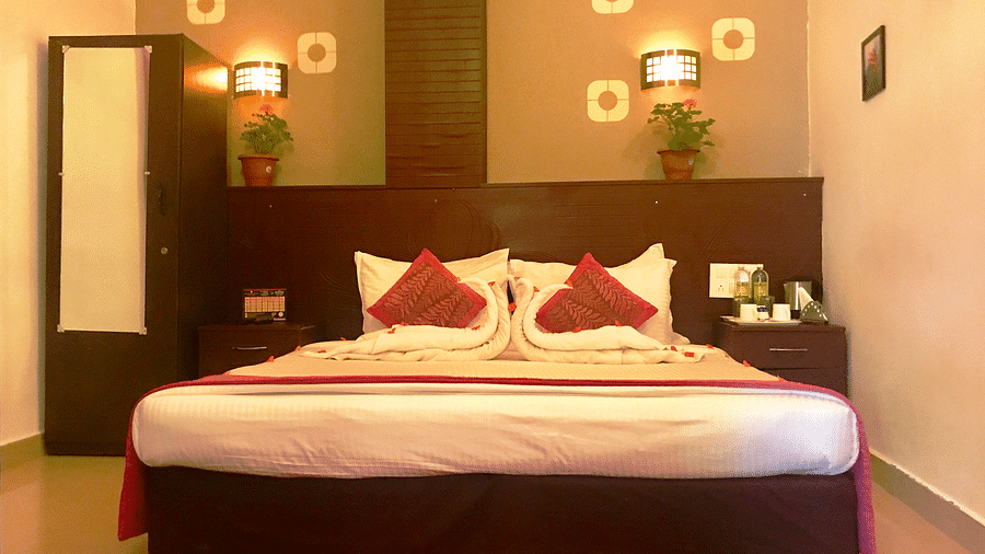 Image of a room with a bed and decors on the wall above the bed at Coorg Jungle Camp Backwater Resort, Kushalnagar.