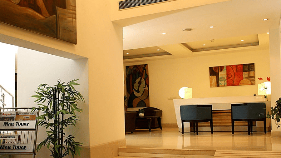 The grand lobby at Eastlynn Collections Huda City Centre, Gurugram, features tall ceilings and a polished stone staircase.