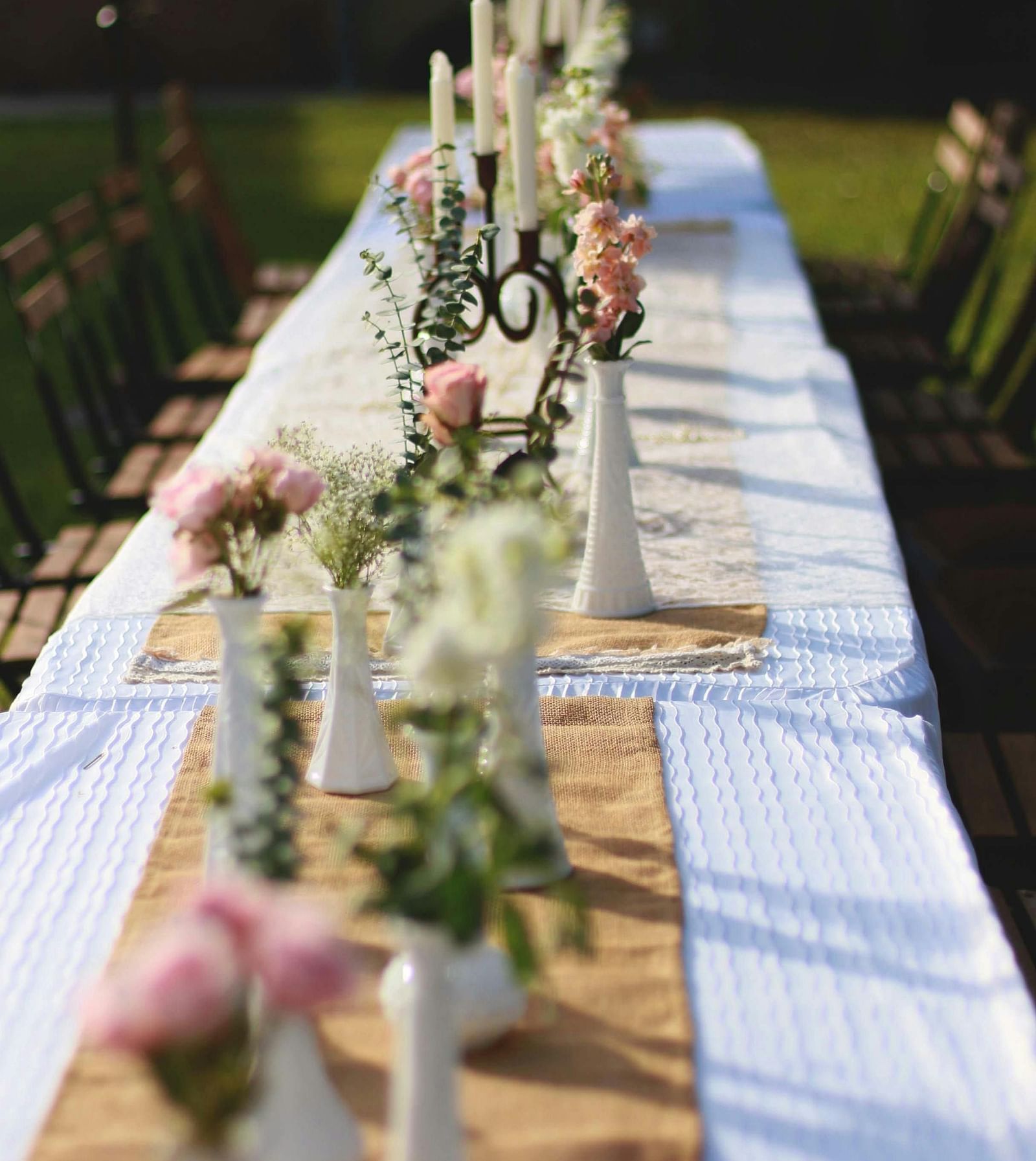 A view of an outdoor dining arrangement in a garden during the day - The Groveland Hotel.