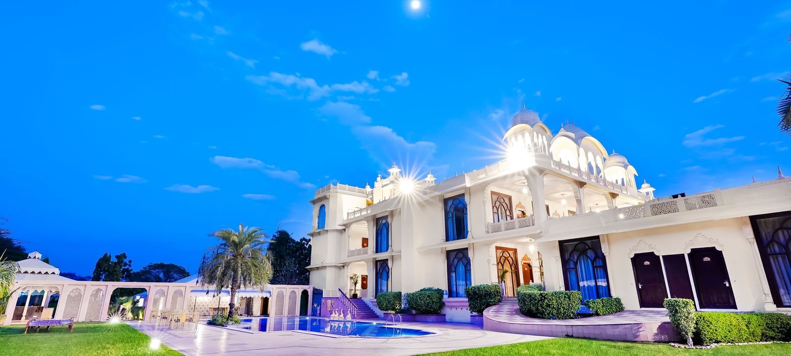 An overview of the facade of Rajasthali Resort & Spa, Jaipur with a swimming pool and lawn in view - Delhi Jaipur Highway Resort.