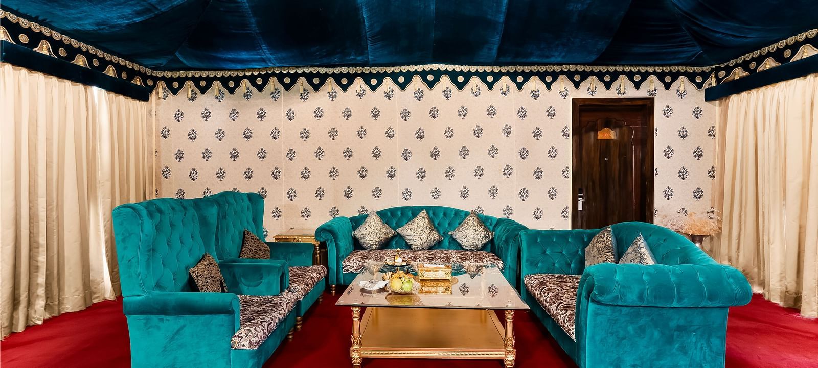 An overview of the living area inside a tent with sofas and a coffee table - Rajasthali Resort & Spa, Jaipur.