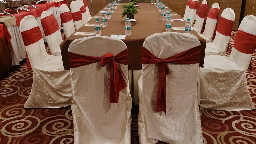 A conference room arranged for a meeting with red chairs and a patterned carpet - The President Hotel Jayanagar, Bangalore