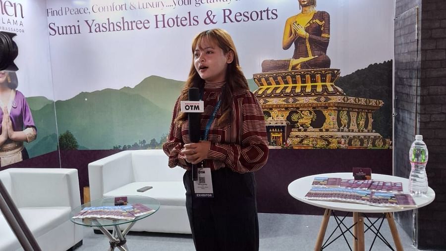 A representative speaking on camera at the Sumi Yashshree Hotels & Resorts booth, highlighting the brand's promise of peace, comfort, and luxury.
