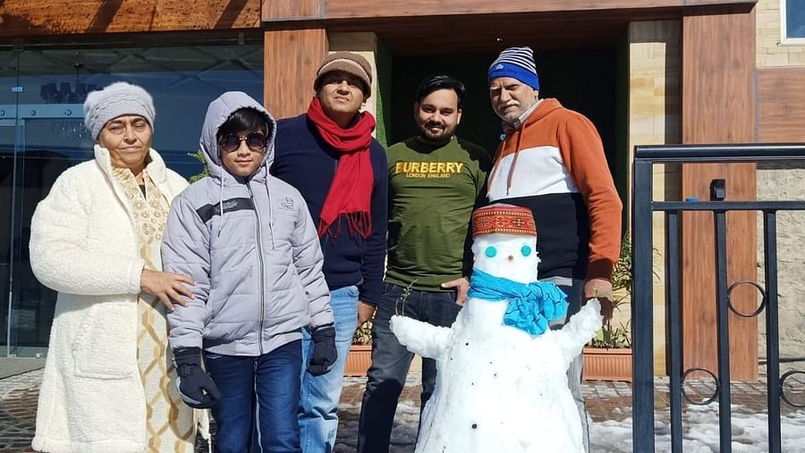 People standing outside next to a small snowman - The Orchid Hotel Shimla