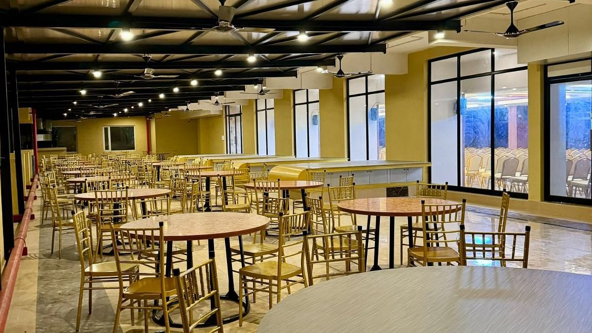 Image of Karai Café with round tables, chairs, and lights on the ceiling at Le Royale Palace.