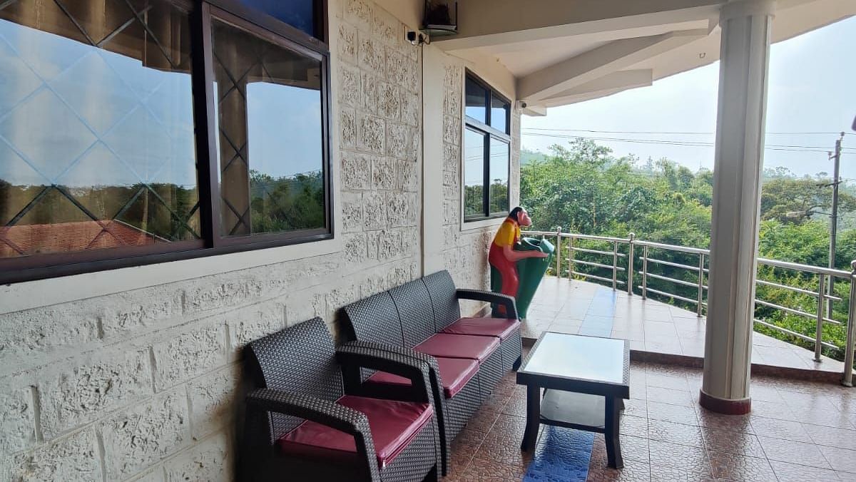 a lovely patio with tiled floor, chairs, table and potted plants | Standard Room |  Woodstock Resorts, Coorg