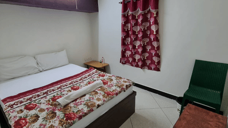 Standard guest room with double bed, tiled flooring, and seating area at Dream Vision Guest House, Diu.