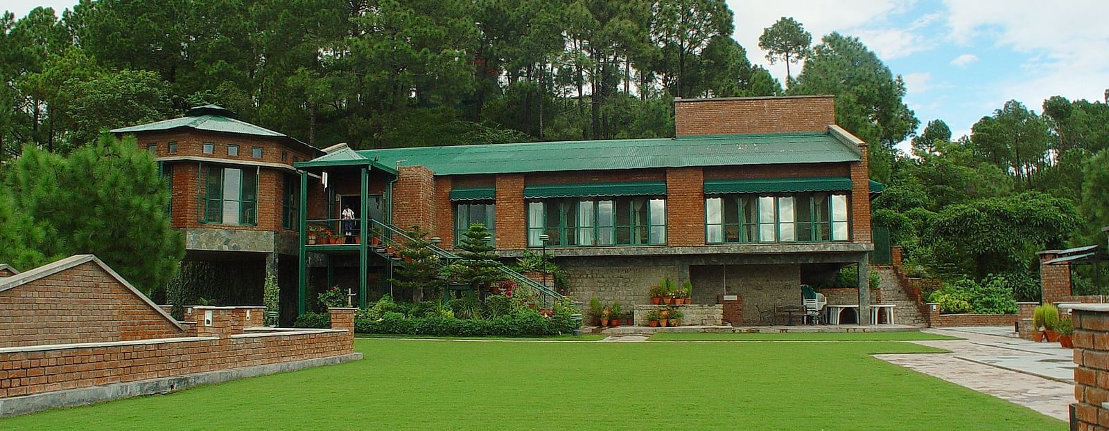  An exterior view of restaurant with a beautiful mountain backdrop and foliage at - Baikunth Resort, Kasauli 