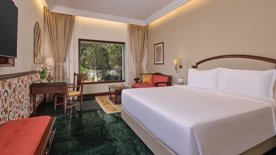 The Premium King Garden View Room at The Ummed Ahmedabad offers a spacious interior with warm lighting and a cozy king size bed