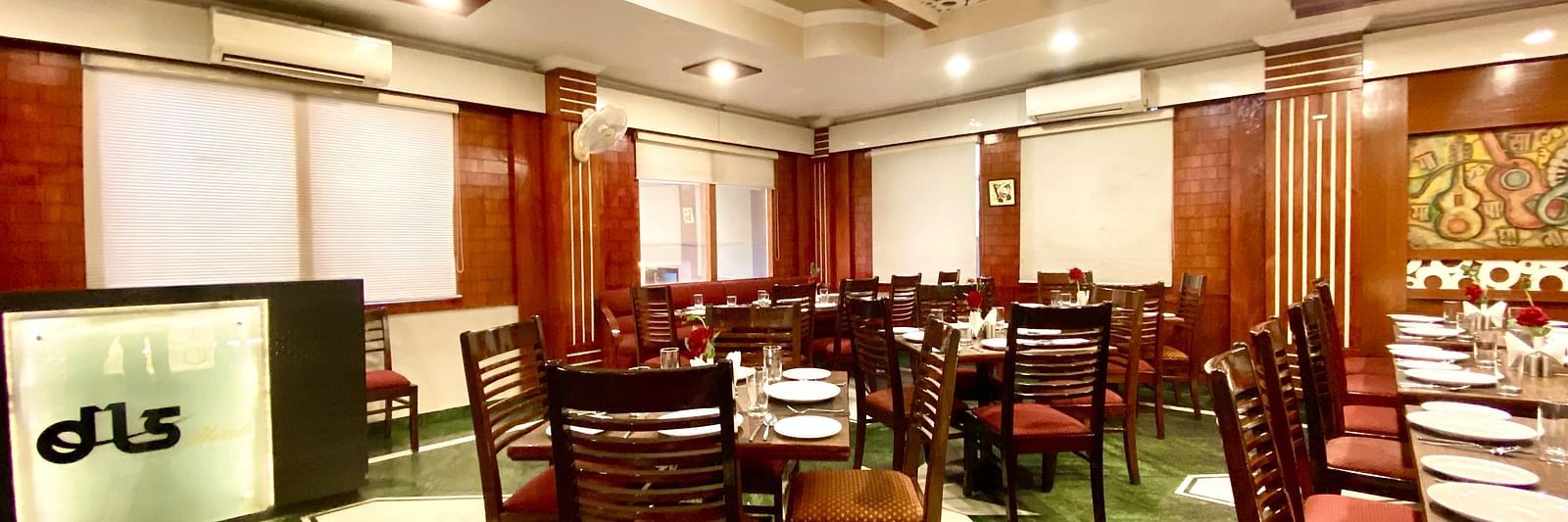  Dining area at DLS Park Grace, Haridwar featuring ample seating area, assorted plates, bright lighting and marble flooring.