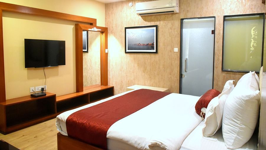 A sideview of bed in Presidential Suite with TV and A/C | Hotel City Inn, Varanasi