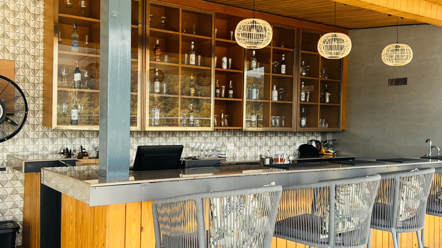 Clove bar at ABN Sarovar Portico, Jim Corbett with rows of metal high stool aligned in front of a yellow desk.