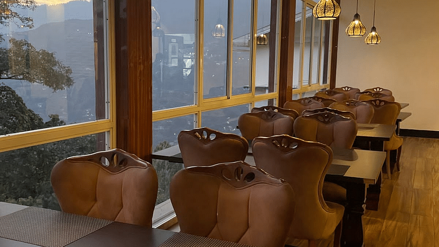 Seating arrangements inside the Restaurant with large windows - Sumitel Gangtok