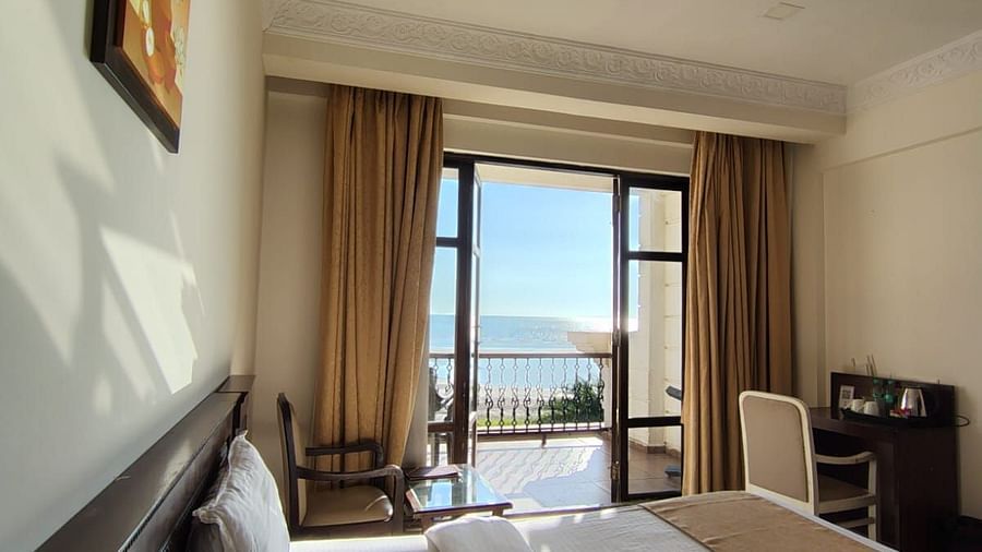 A spacious room at VITS ExcellenSea, Dapoli, with a king-sized bed, a seating area, and a balcony overlooking the ocean.