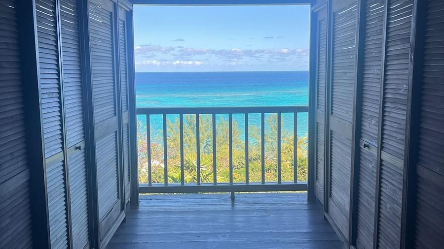 Wooden hallway leading to a balcony with ocean view | A Stone's Throw Away
