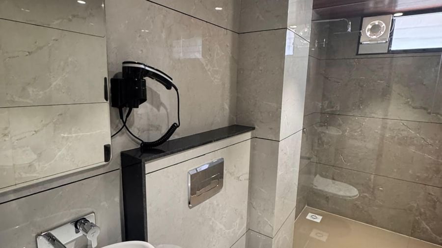 Modern bathroom at Hotel Mumbai House, Vijay Nagar, Indore, equipped with stylish sink, tiled walls, and essential amenities for guest convenience.