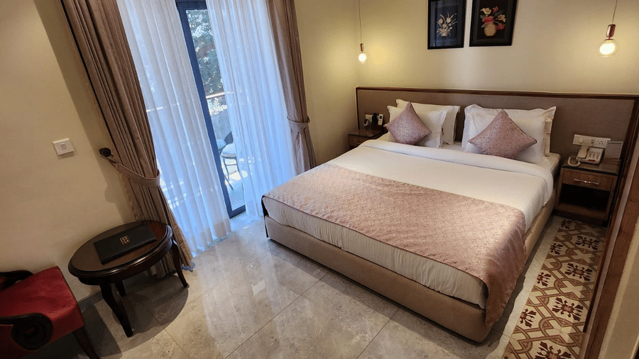 Spacious Super Deluxe Room featuring a comfortable bed, modern furnishings and warm lighting at Hotel Southgate Goa, Calangute, creating a relaxing guest retreat.