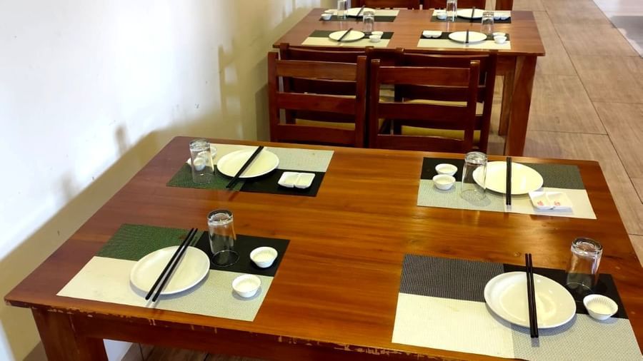 A top-angle shot of a dining table at Ajito restaurant featuring chopsticks kept on the plates arranged on the table at Ilara Hotels & Spa, Tada.