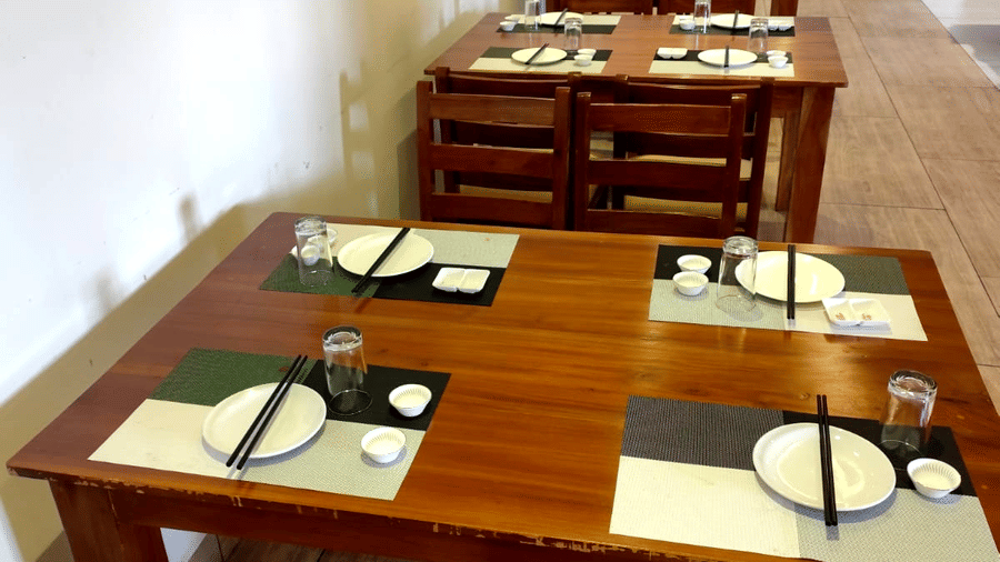 A top-angle shot of a dining table at Ajito restaurant featuring chopsticks kept on the plates arranged on the table at Ilara Hotels & Spa, Tada.