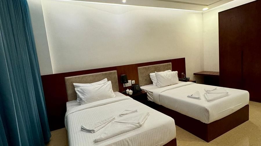 Image of a room with two beds and a chair at Le Royale Palace.