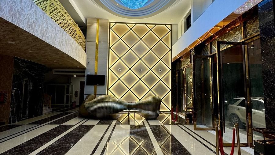 Image of a hallway with embelished ceiling and glass doors on the side at Le Royale Palace.