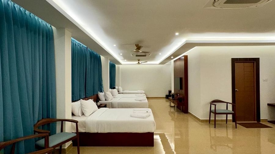 Image of a room with six beds, three chairs and seating area at Le Royale Palace.