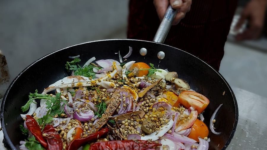 A close shot of vegetables in a pan being tossed by a person | Matsya Island Retreat