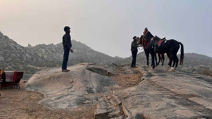 An image of horses on top a mountain with their caretakers - Utsav Camp Sariska